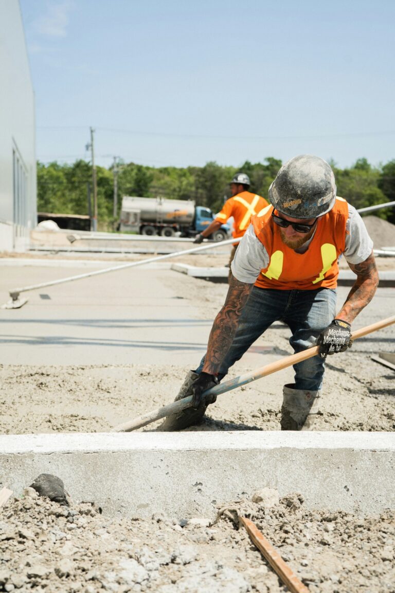 Concrete being spread by hand on site
