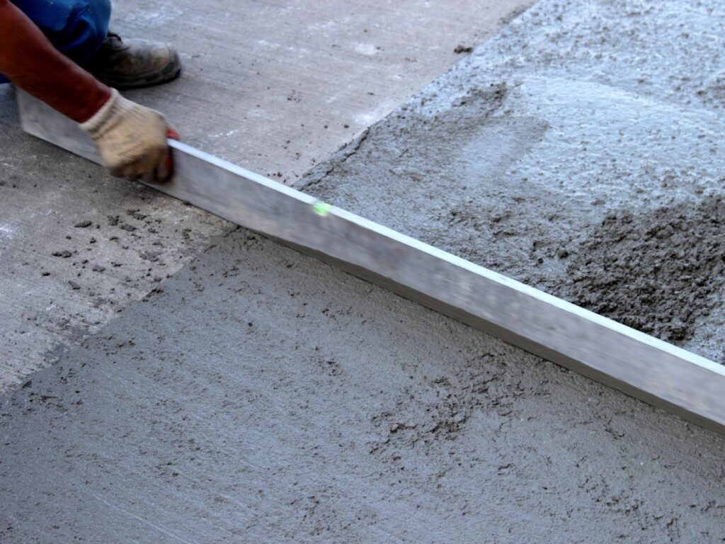 Levelling concrete screed with a straight edge