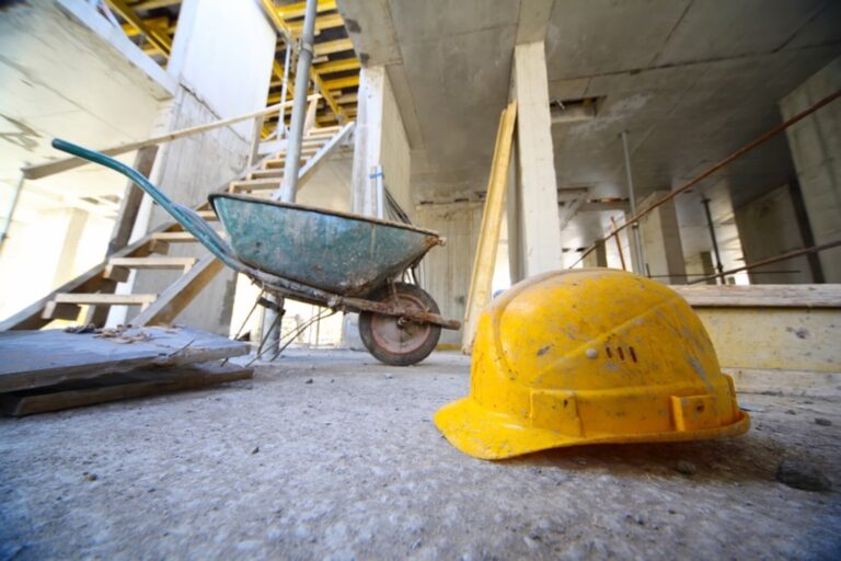 Wheelbarrow and hard hat on a construction site